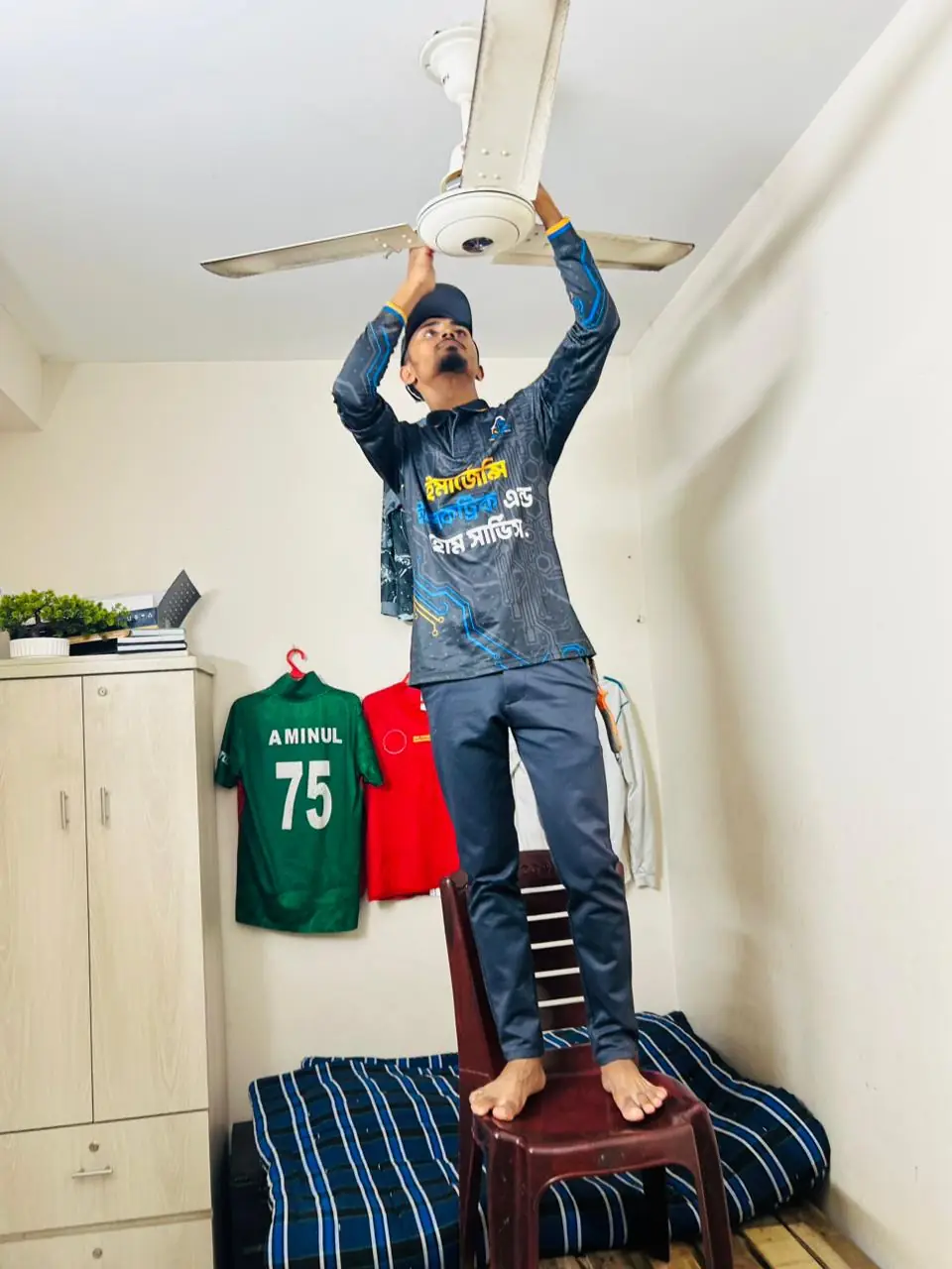 Technician installing a ceiling fan in a flat in Uttara