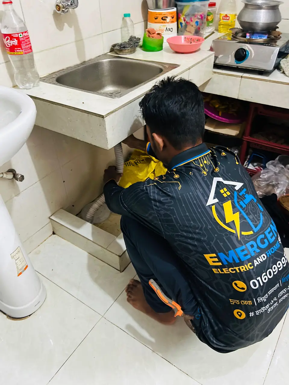 Plumber repairing the water line under a kitchen sink